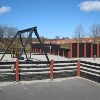 A ball court and swings at the playground at Lindevangen